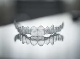 39541374 - invisible invisalign plastic dental teeth brackets tooth braces isolated with shallow depth of focus artistic photograph.